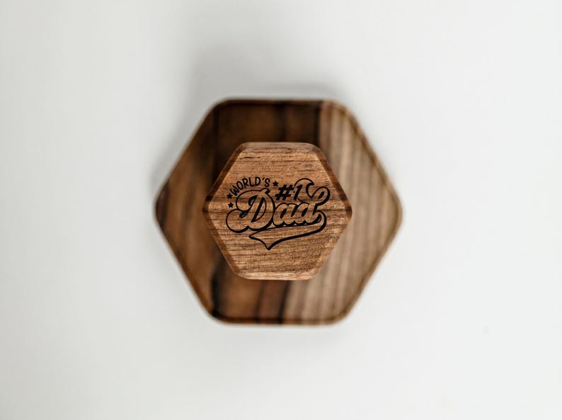 A wooden hexagonal object with the text "World's Dad" engraved on it.