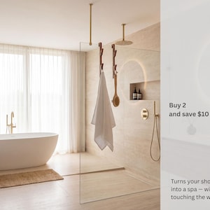 a modern bathroom with a large bathtub, a shower enclosure, and a towel rack. The bathroom has a minimalist and clean design, with a neutral color scheme.