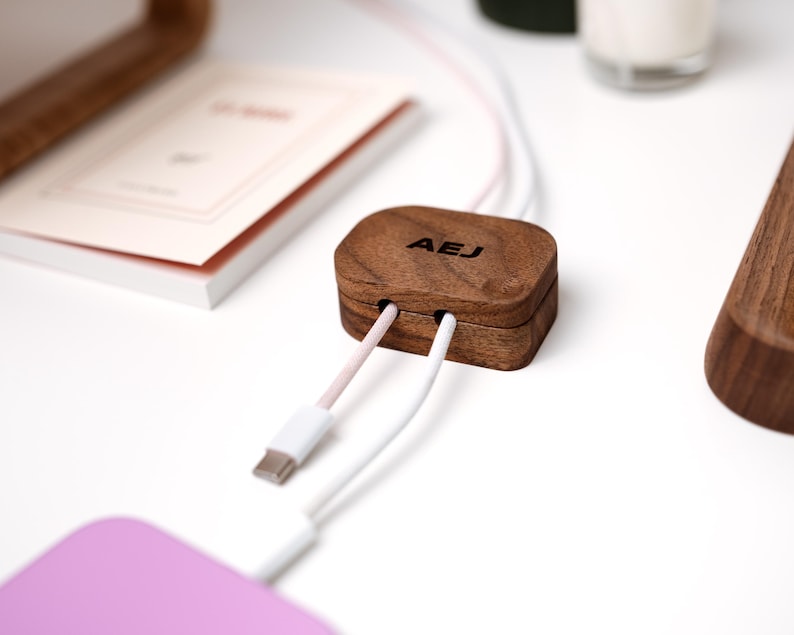 a wooden box with a USB cable plugged into it, placed on a white surface.