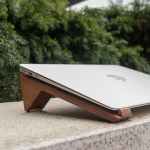 an apple laptop sitting on top of a stone slab