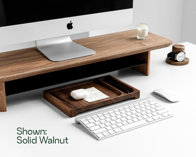 a wooden desk with a computer monitor, keyboard, mouse, and other office supplies arranged on it.