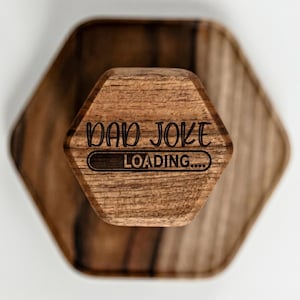 A wooden object with the text "DAD JOKE LOADING..." printed on it.