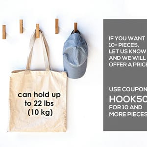 a beige tote bag and a blue baseball cap hanging on hooks, along with text promoting a sale.