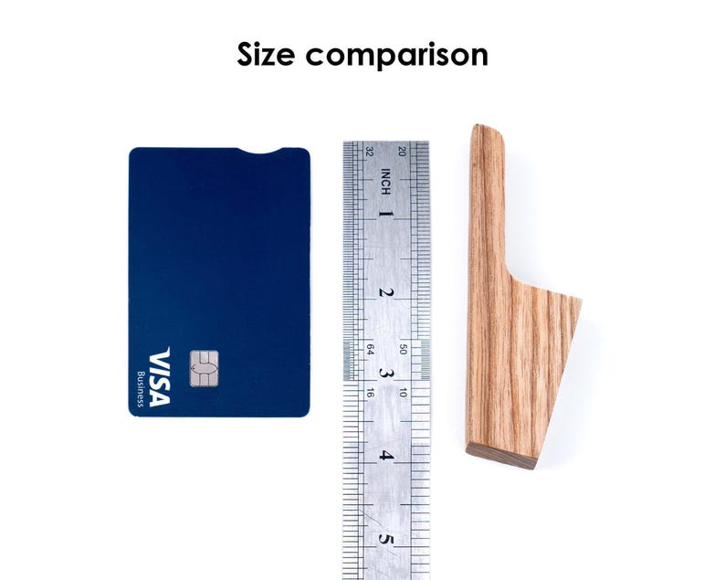a blue Visa credit card, a ruler, and a wooden object, likely a toothbrush, arranged on a white background.