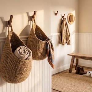 A cozy entryway with a wooden bench, a woven basket hanging on the wall, and a woven basket with a folded blanket inside.