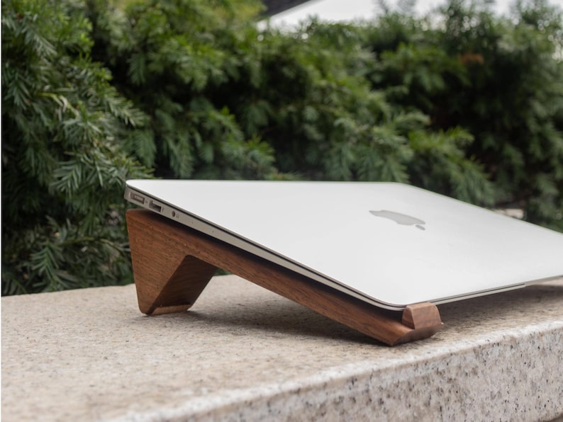 an apple laptop sitting on top of a stone slab
