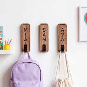Personalisierte Wandhaken aus Holz mit Namensaufdruck – Individuelle Familiengarderobe für rustikale Wohnräume, aus dunklem Walnuss- oder hellem Eschenholz
