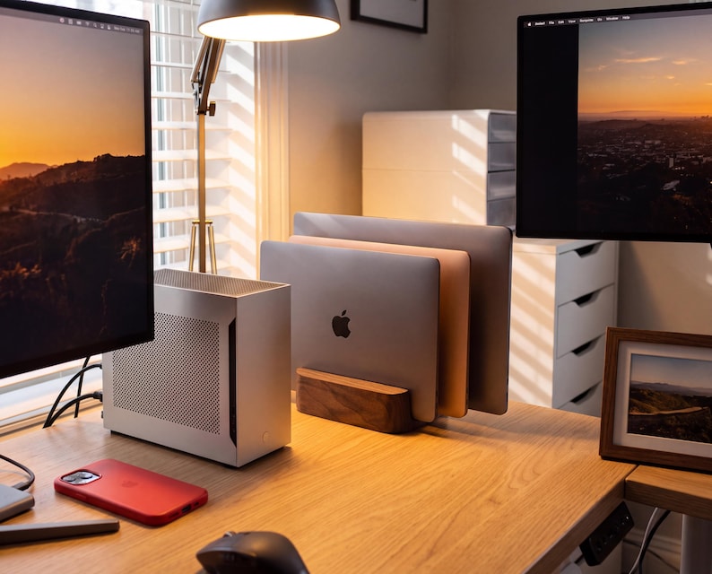 a well-organized workspace with a wooden desk, a laptop, a monitor, and a mouse. The desk has a wooden stand that holds the laptop and monitor, creating a neat and tidy appearance.
