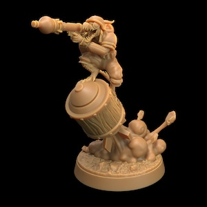 May include: A miniature figurine of a green-skinned creature wearing a helmet and holding a rocket launcher. The creature is standing on a bomb that is exploding. The figurine is painted in a brown color.