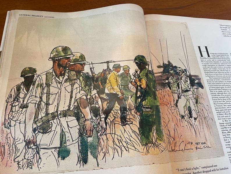 May include: A printed illustration on a book page depicting soldiers in green uniforms and helmets walking through tall grass. A helicopter is visible in the background, and a figure in a yellow jacket stands among the group. Text reads VIET NAM.