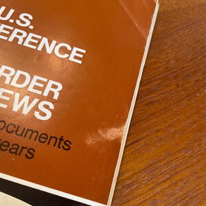 May include: A vintage magazine cover with a brown background and white text reading U.S. CONFERENCE, ORDER, NEWS, and documents years. The date NOVEMBER 14, 1967 is printed at the top. The paper shows signs of wear with a small crease on the top right corner.