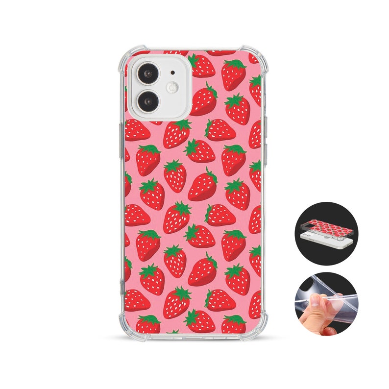 May include: A clear phone case featuring a pink backdrop adorned with a pattern of red strawberries and green leaves. The case is designed for a smartphone and has a protective bumper around the edges.