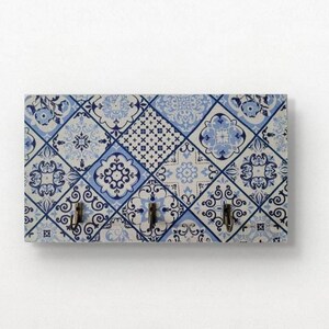 Puede incluir: Un porta llaves blanco y azul con tres ganchos. El patrón recuerda a los azulejos portugueses tradicionales.