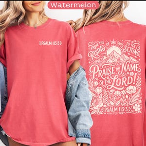 May include: A watermelon-colored t-shirt with the text "PSALM 113:3" on the front. The back of the shirt features a graphic with the words "FROM THE RISING OF THE SUN TO ITS SETTING. PRAISE THE NAME OF THE LORD! PSALM 113:3" in a decorative font, with a mountain and floral design.