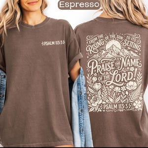 May include: Espresso-colored t-shirt with the text "PSALM 113:3" on the front. The back features a mountain and floral design with the words "PRAISE THE NAME OF THE LORD!" and "FROM THE RISING OF THE SUN TO ITS SETTING."