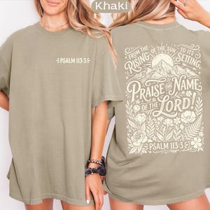 May include: Khaki-colored t-shirt with the text "PSALM 113:3" on the front. The back of the shirt features a graphic with the words "FROM THE RISING OF THE SUN TO ITS SETTING PRAISE THE NAME OF THE LORD!" and "PSALM 113:3".