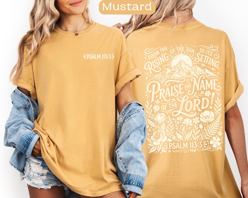May include: Mustard-colored t-shirt with the text "PSALM 113:3" on the front. The back of the shirt features the phrase "PRAISE THE NAME OF THE LORD!" with floral and mountain illustrations. The text "FROM THE RISING OF THE SUN TO ITS SETTING" is also included.