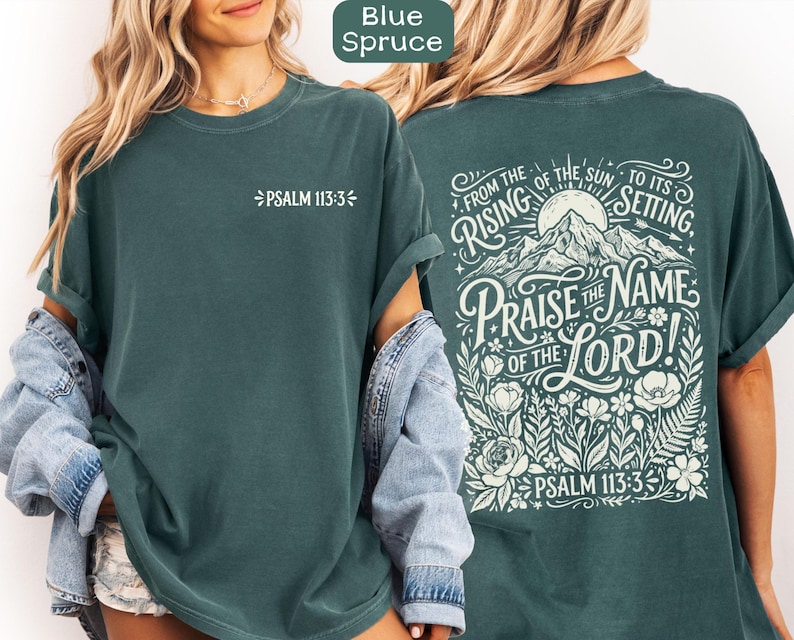 May include: Blue Spruce t-shirt with white text. The front of the shirt has "PSALM 113:3". The back of the shirt has the text "FROM THE RISING OF THE SUN TO ITS SETTING, PRAISE THE NAME OF THE LORD! PSALM 113:3" with a mountain and floral design.