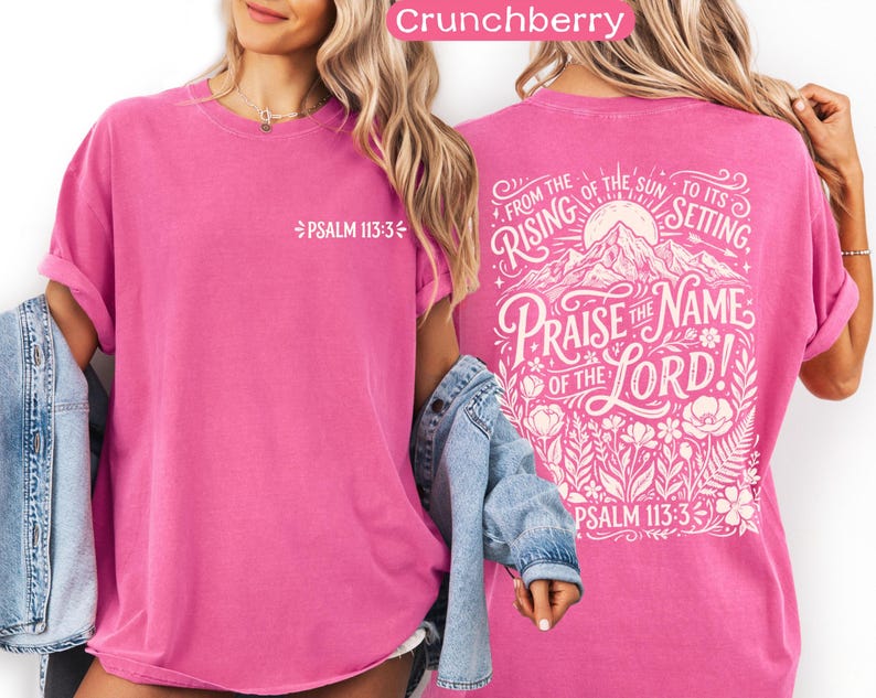 May include: A vibrant pink t-shirt with rolled-up sleeves. The front features the text "PSALM 113:3" in white. The back displays a detailed graphic with the words "Praise the Name of the Lord!" and "From the rising of the sun to its setting," along with floral elements.
