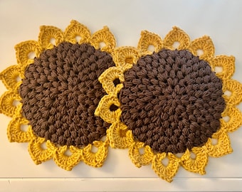 May include: Two crocheted sunflower pot holders with brown centers and yellow petals.