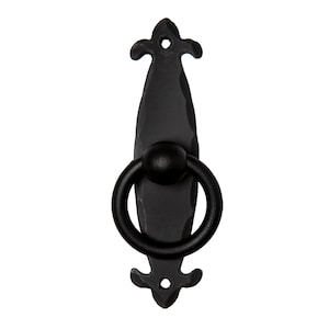 May include: Black metal door pull with a ring handle and decorative fleur-de-lis accents.
