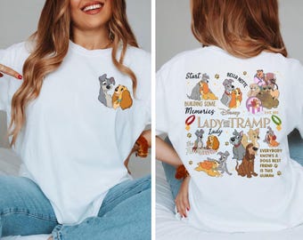 Puede incluir: Camiseta blanca con un diseño de La Dama y el Vagabundo. La parte delantera tiene una pequeña imagen de los perros. La parte trasera tiene un diseño más grande con las palabras "Start Building Some Memories Disney Lady and the Tramp".
