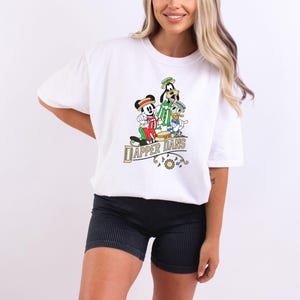 May include: White t-shirt with a graphic of Mickey Mouse, Goofy, and Donald Duck playing instruments. The text "Dapper Dans" is printed below the graphic.