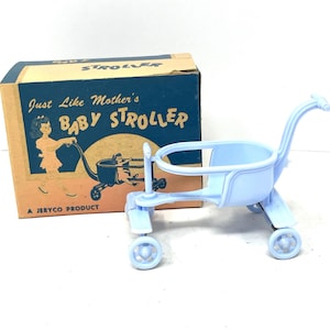 May include: A vintage baby stroller toy in light blue, with a matching box. The box is tan with blue text that reads "Just Like Mother's Baby Stroller" and features an illustration of a woman pushing a stroller. A Jeryco product.