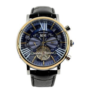 May include: A luxury wristwatch with a black leather band and a silver and gold-toned case. The watch face is navy blue with gold accents, featuring Roman numerals, day and date displays, and the brand name "Thomas Earnshaw".