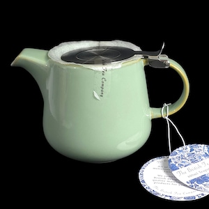 Op de afbeelding: Een lichtgroene keramische theepot met een roestvrijstalen infuser en handvat. De theepot heeft een inhoud van 600 ml en bevat een label met de tekst "The British Tea Company". Ontworpen voor het zetten van thee.
