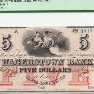May include: An obsolete banknote from Hagerstown Bank, Maryland, with the text "Will pay FIVE DOLLARS". The note features an illustration of two women and ornate detailing, with the number "5" displayed. The note is graded as "Superb Gem New".