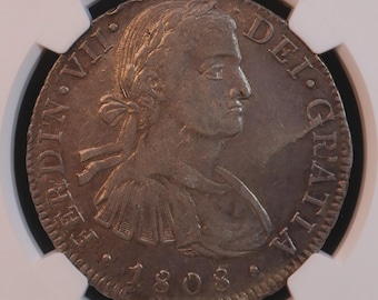 Könnte beinhalten: Eine Silbermünze mit dem Profil eines Mannes mit Lorbeerkranz, der Inschrift "FERDIN VII DEI GRATIA" und dem Jahr 1803. Die Münze ist in einem Schutzhalter eingeschlossen.