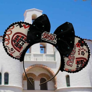 May include: A pair of black mouse ears with a white and red patterned fabric featuring the text "San Diego State" and a black bow with a white patch that reads "San Diego SDSU State University".