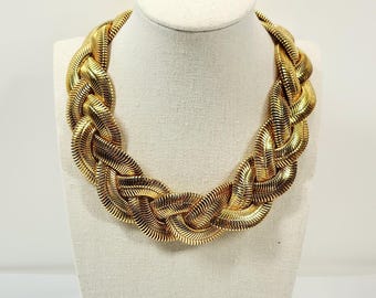 Collar Omega trenzado de tres hebras en tono dorado, pulido brillante.