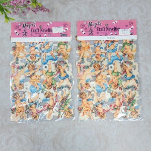 May include: Two identical packets of Hazel's Craft Novelties die-cut paper cherubs. Each clear plastic bag contains multiple small, colourful illustrations of winged infants with floral garlands, blue clouds, and ribbons, labelled RD 30.