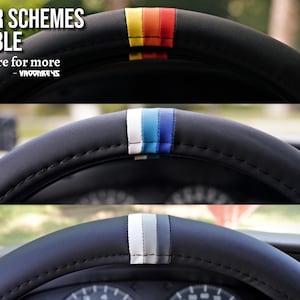 May include: Three steering wheel covers with different colored stripes. The top cover has red, orange, and yellow stripes. The middle cover has blue, white, and light blue stripes. The bottom cover has gray, white, and black stripes.