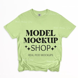 Puede incluir: Una camiseta verde claro con el texto "MODEL MOCKUP SHOP" y "REAL POD MOCKUPS" en negro.