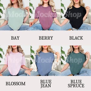 May include: Six different colored t-shirts are displayed. The colors are bay, berry, black, blossom, blue jean, and blue spruce. Each shirt is a solid color and has a crew neck. The text "Mock Shop" is visible on some of the shirts.