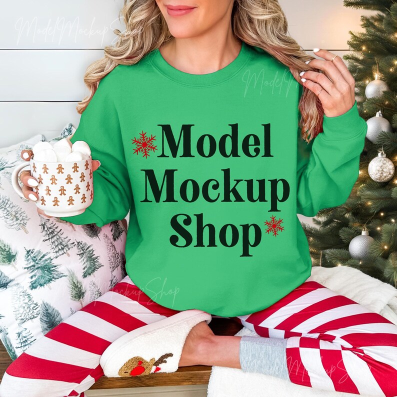 May include: A woman wearing a green sweatshirt with the text "Model Mockup Shop" and red and white striped pants. The sweatshirt has a snowflake design on each side of the text.