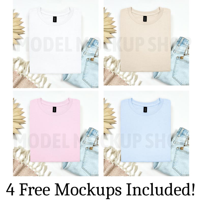 May include: Four folded t-shirts in different colors: white, beige, pink, and light blue. Each shirt is laid flat on a white surface with a pair of denim shorts and a woven rug beside it. The shirts have a crew neck and short sleeves.