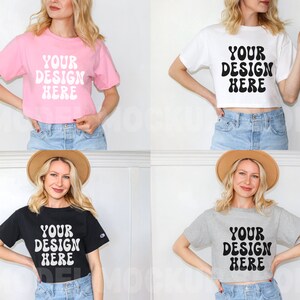 May include: Four women are wearing different colored cropped t-shirts with the text "YOUR DESIGN HERE" in a retro font. The shirts are pink, white, black, and gray. The women are wearing jeans and have their hair down.