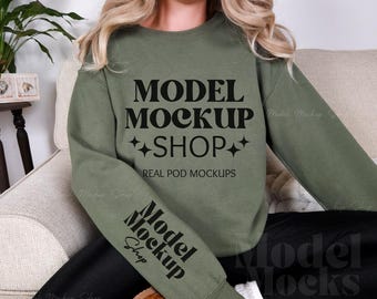 May include: A green sweatshirt with the text "MODEL MOCKUP SHOP" and "REAL POD MOCKUPS" printed on the front. The text "Model Mockup Shop" is printed on the left sleeve.
