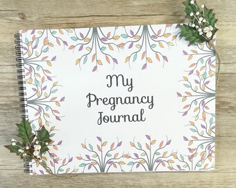 May include: A white pregnancy journal with a spiral binding. The cover features a colorful floral design with the text "My Pregnancy Journal".