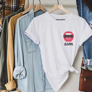 May include: White t-shirt with a red open mouth graphic and the word "ASMR" printed below it.