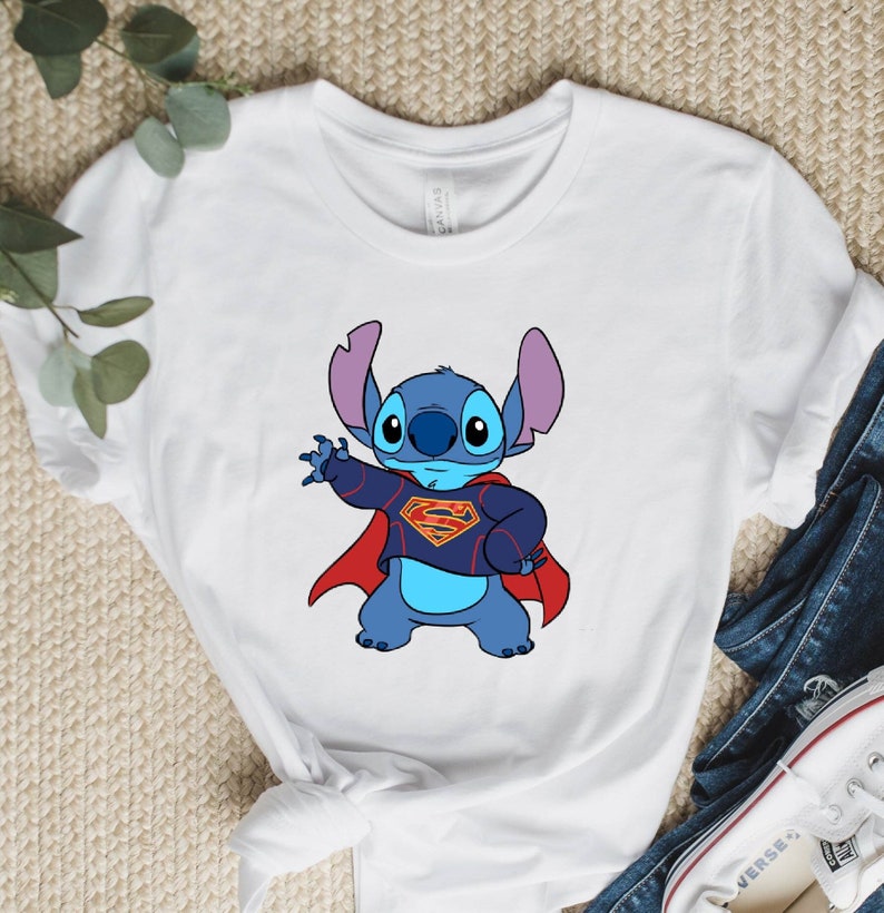 May include: White t-shirt with a blue Stitch character wearing a red Superman cape and a blue and red Superman suit.