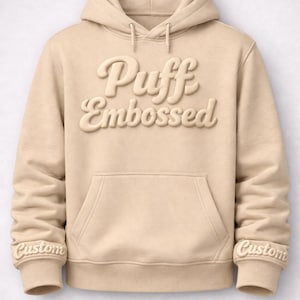A beige hoodie with the text "Puff Embossed" printed on it.