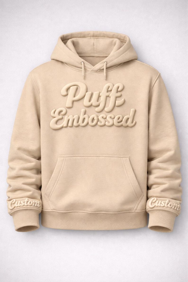 A beige hoodie with the text "Puff Embossed" printed on it.