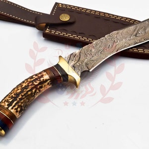 Puede incluir: Un cuchillo de caza con mango de asta de ciervo marr&oacute;n y hoja de acero damasco. El cuchillo viene con una funda de cuero marr&oacute;n.