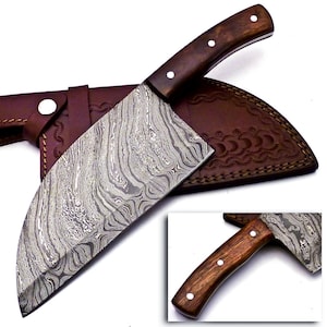 May include: A large, Damascus steel cleaver knife with a dark wooden handle and three white rivets. The blade has a unique, swirling pattern. It rests on a brown leather sheath with decorative stitching and a snap closure. A smaller inset image shows a close-up of the handle.