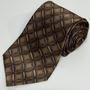 May include: Brown tie with a repeating diamond pattern. The tie features a mix of brown, tan, and gray tones. The tie is made of a smooth, possibly silk, material and is rolled up on a white surface.